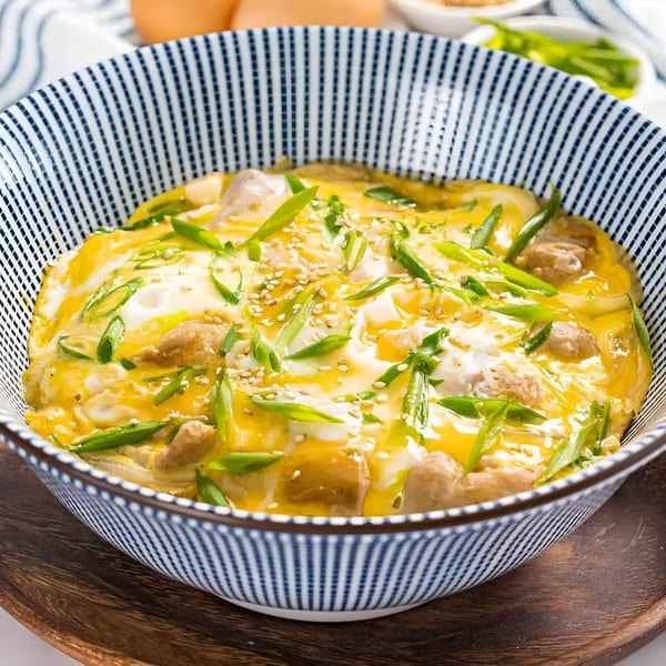 A bowl of Hanabi Sushi's Oyakodon, featuring chicken, egg, green onions, and sesame seeds.
