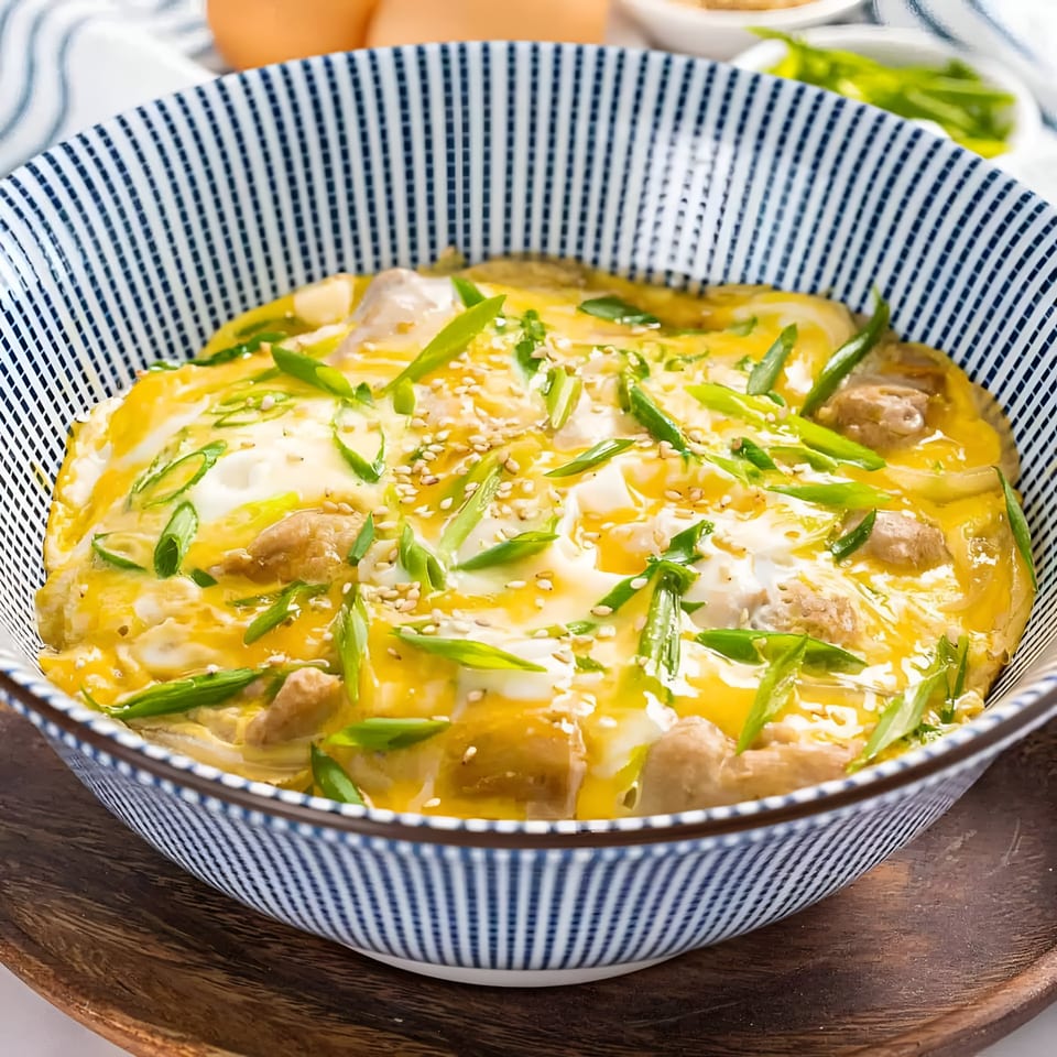 A bowl of Hanabi Sushi's Oyakodon, featuring chicken, egg, green onions, and sesame seeds.